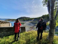 Strandlinjen som kan sees mellom de to personene er dannet i skredmassene etter et kvikkleireskred ved Kråkenes, Alta, som gikk i 2020. Bildet er tatt året etter.
