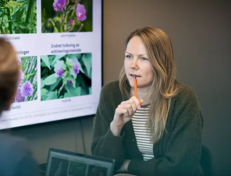 To personer sitter i et møterom under et faglig møte