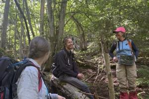 Tre personer i en skog som kartlegger