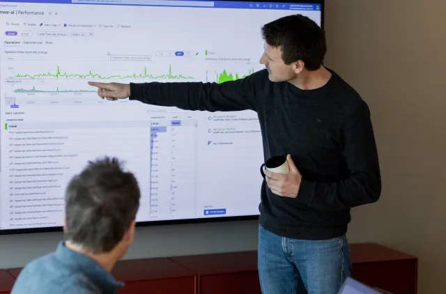 Person peker på en skjerm med innhold under en faglig gjennomgang